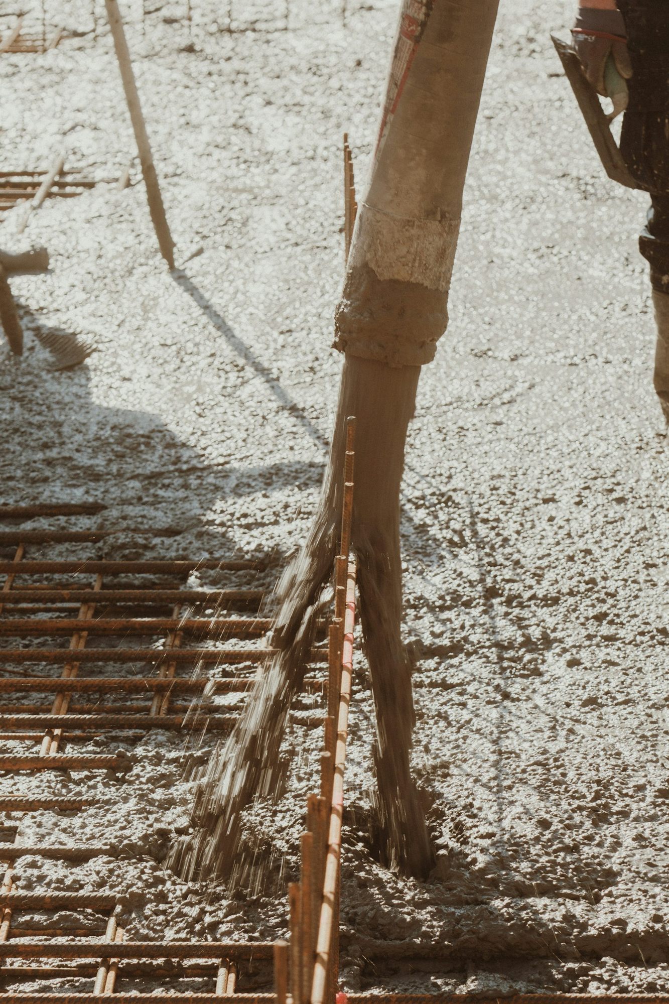 Concrete being poured across reinforcing steel
